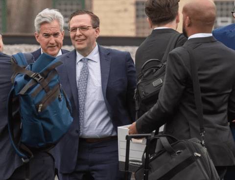 a photograph of James Snyder in a business suit in a group of similarly dressed men