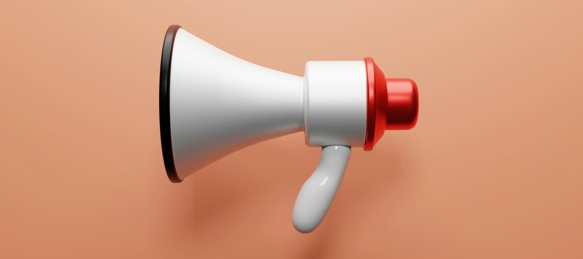 a white and red megaphone on a salmon colored background