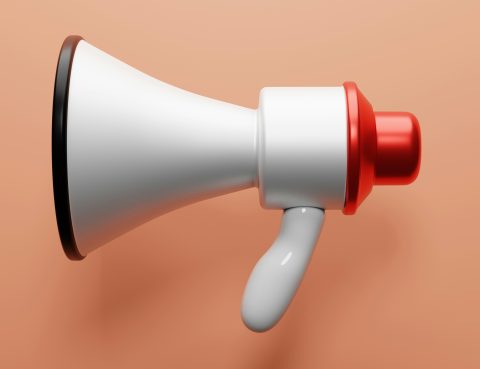 a white and red megaphone on a salmon colored background