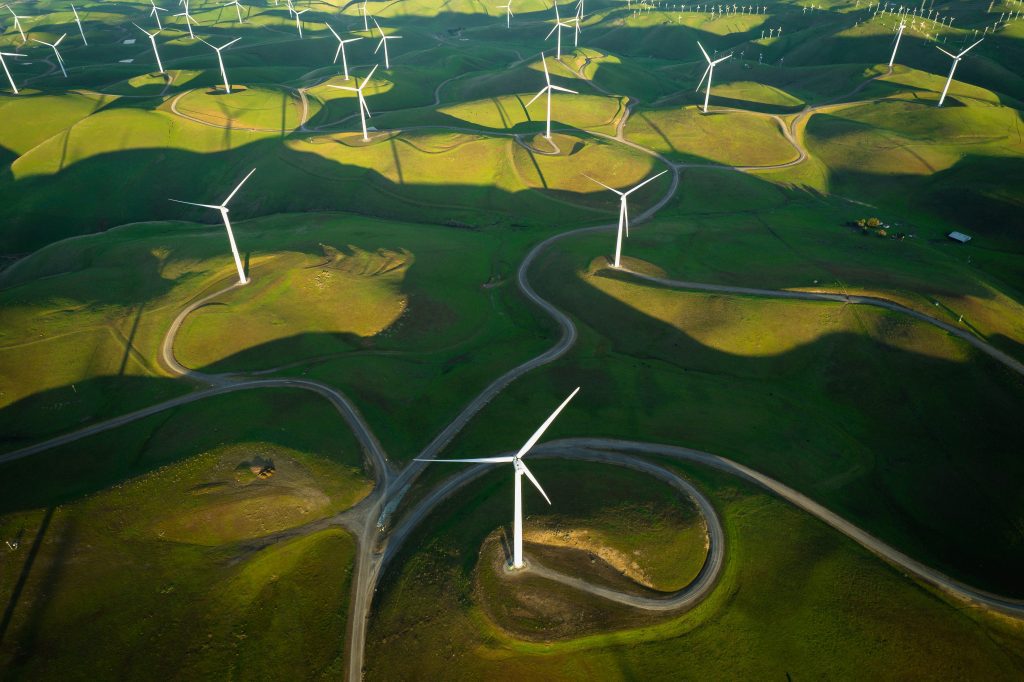 aerial shot of windmills on rolling green hills