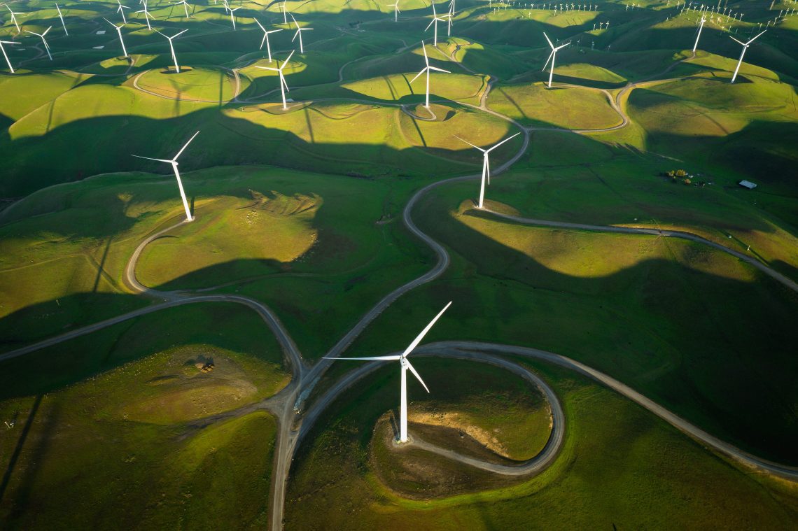 aerial shot of windmills on rolling green hills