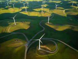 aerial shot of windmills on rolling green hills