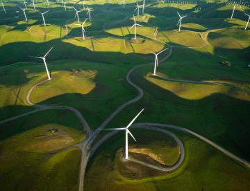 aerial shot of windmills on rolling green hills