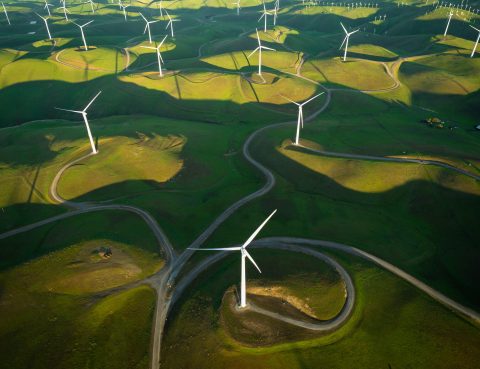 aerial shot of windmills on rolling green hills