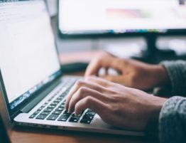 Close up of someone's hands typing on a laptop keyboard