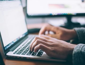 Close up of someone's hands typing on a laptop keyboard