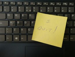 A yellow post-it note on a black keyboard, that says "I quit!"
