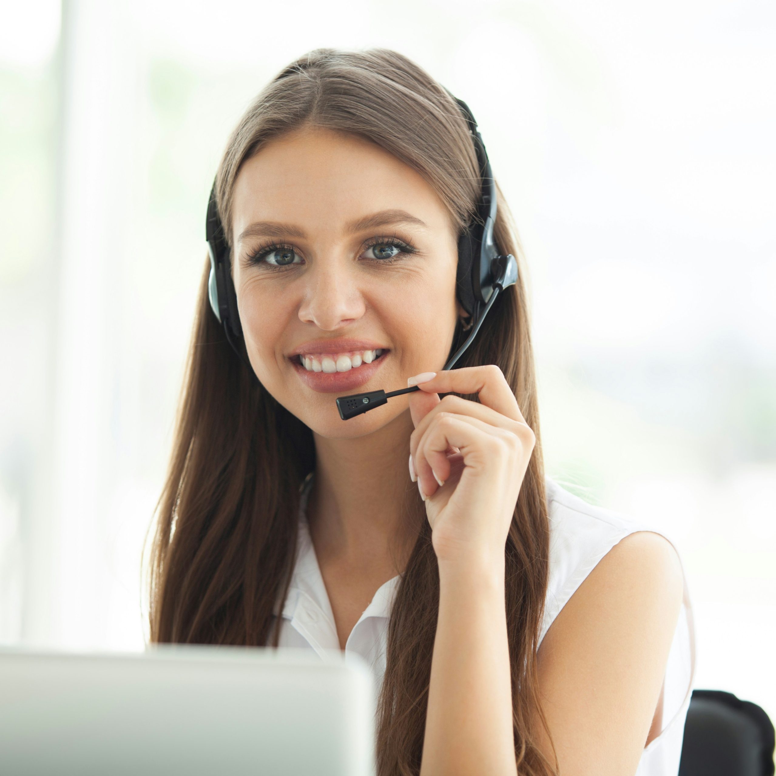 a woman with a headset and microphone on smiling at the camera