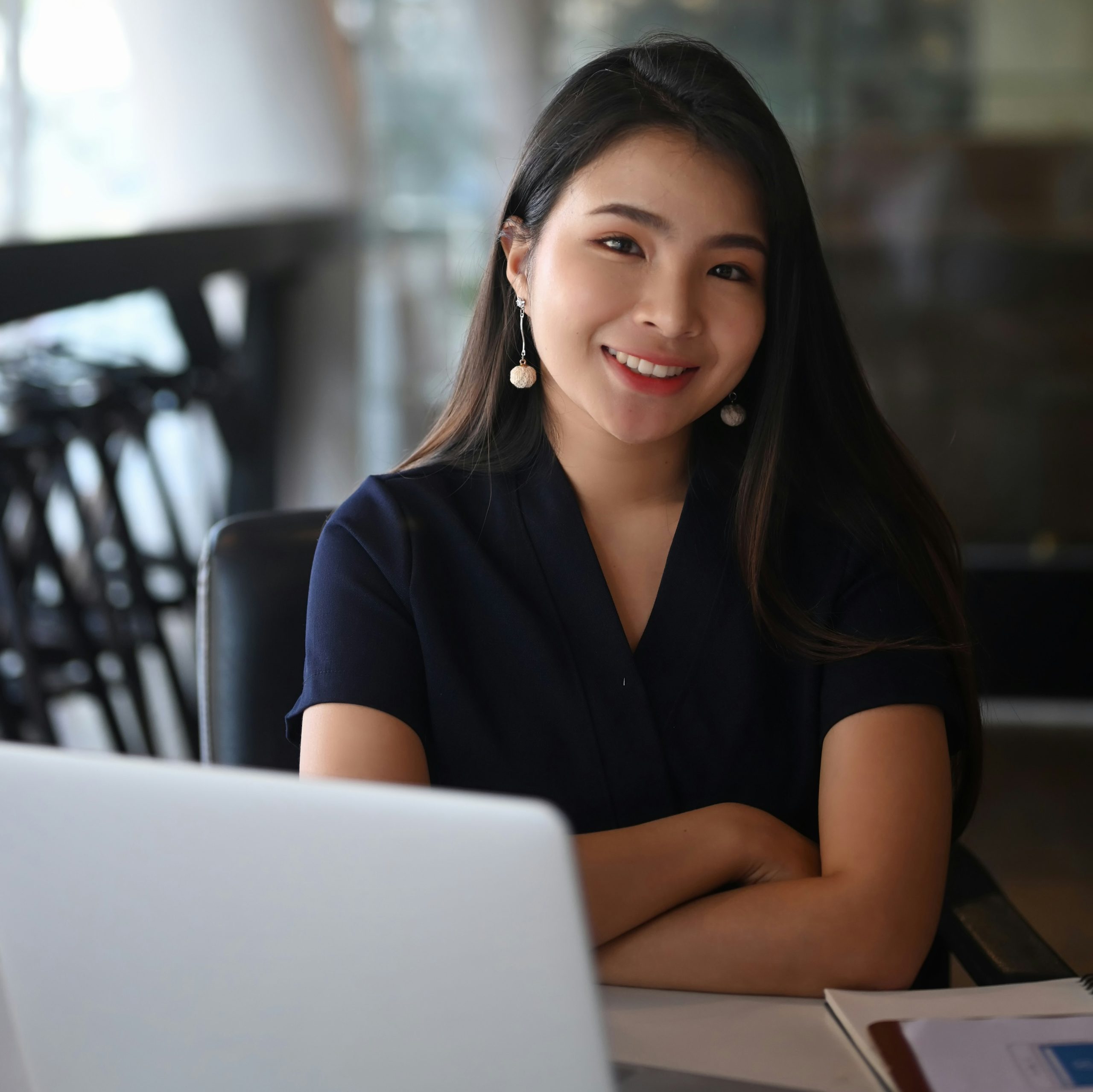 a woman sitting at her work desk smiling at the camera