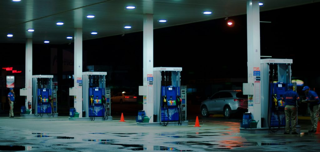 rows of gas pumps at a gas station at night