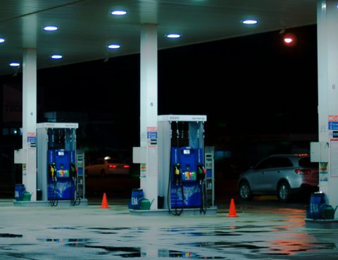 rows of gas pumps at a gas station at night