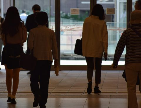 Photo of office workers exiting a building taken from behind them