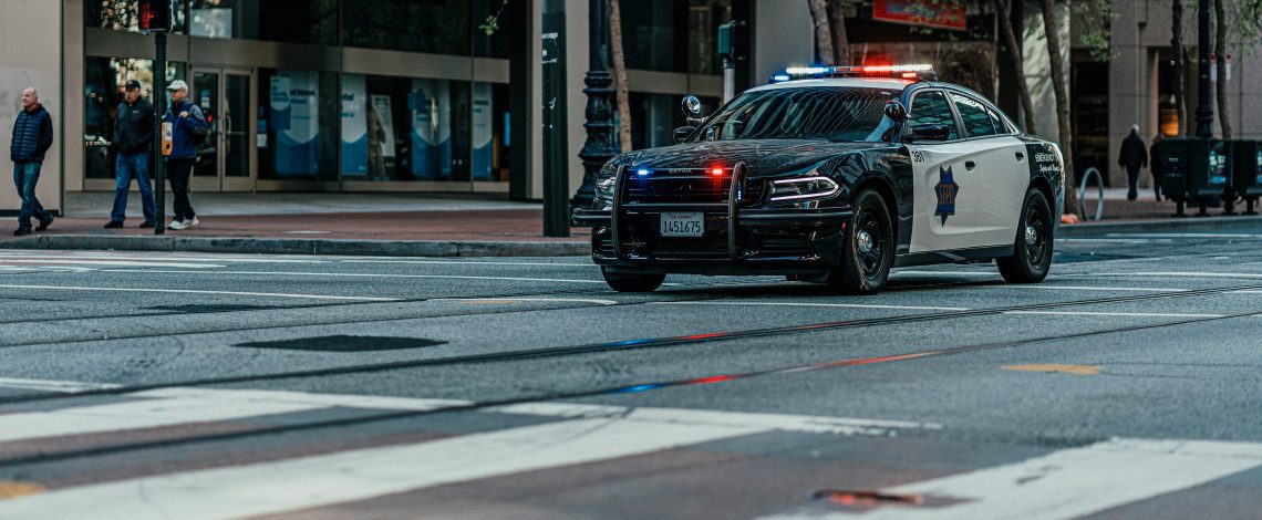 police car on road by a crosswalk
