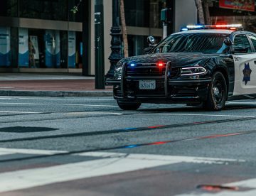 police car on road by a crosswalk