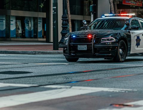 police car on road by a crosswalk