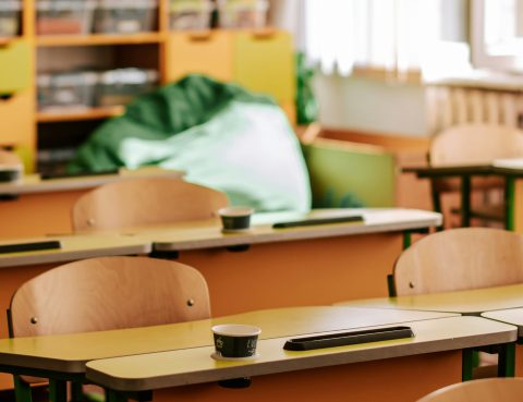 wooden desks in an empty, well lit classroom