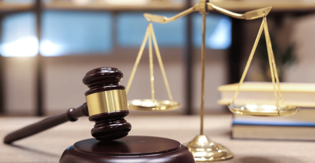 close up photo of a gavel and scale on a desk