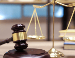 close up photo of a gavel and scale on a desk